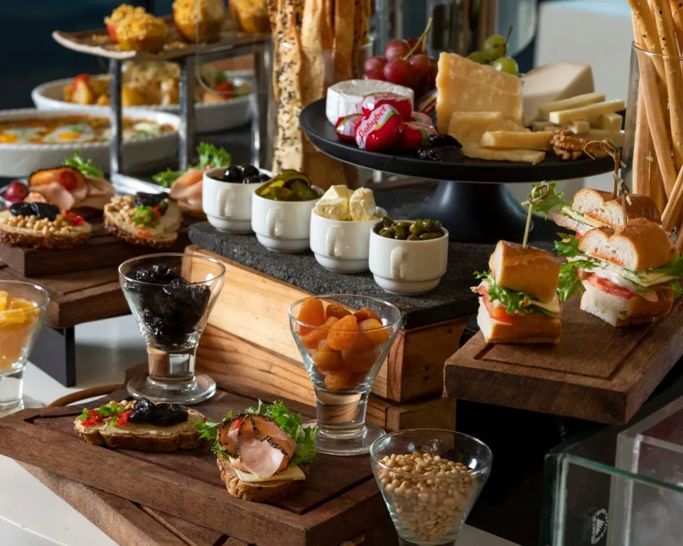Présentation de divers mets et fromages sur un buffet.