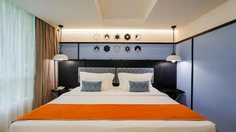 Une chambre lumineuse avec un grand lit et une décoration moderne.