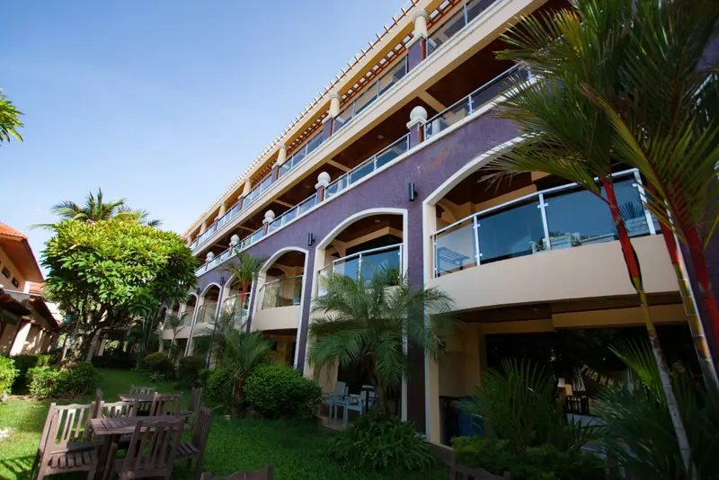 Façade d'un bâtiment avec des balcons et une végétation luxuriante.