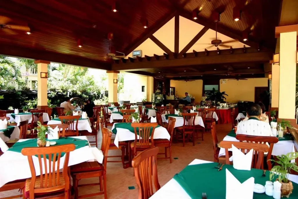 Une salle de restaurant lumineuse avec des tables dressées et des clients attablés.