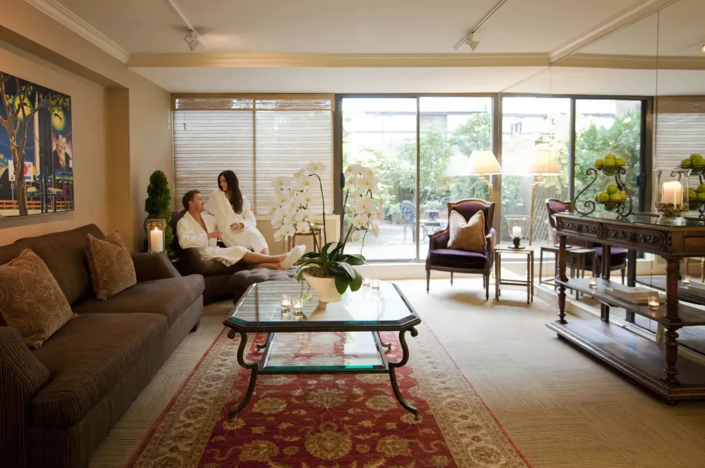 Un couple se détend dans un salon lumineux avec vue sur un jardin.