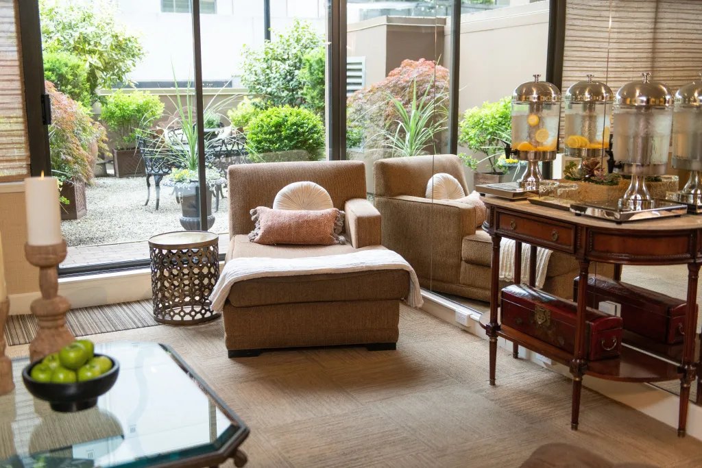 Un espace de détente intérieur avec des fauteuils confortables et une table de service.