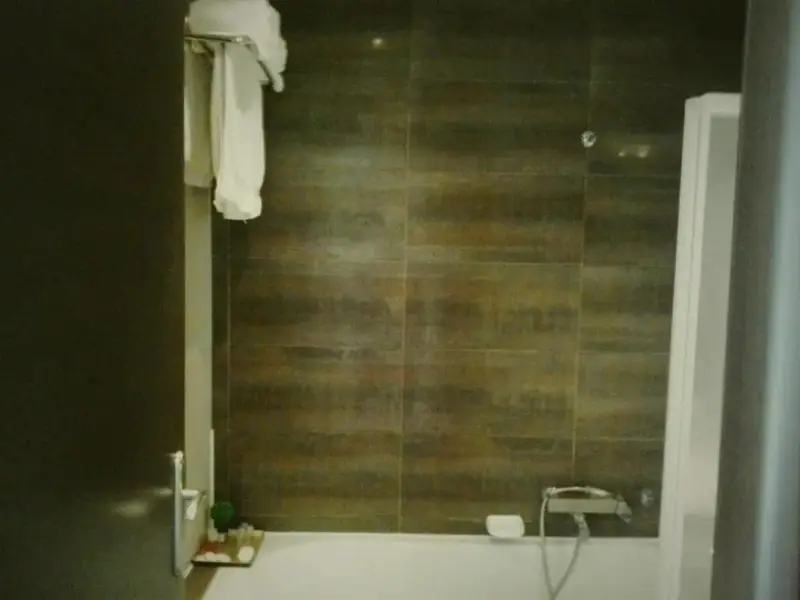 Une salle de bain moderne avec une baignoire et des serviettes suspendues.