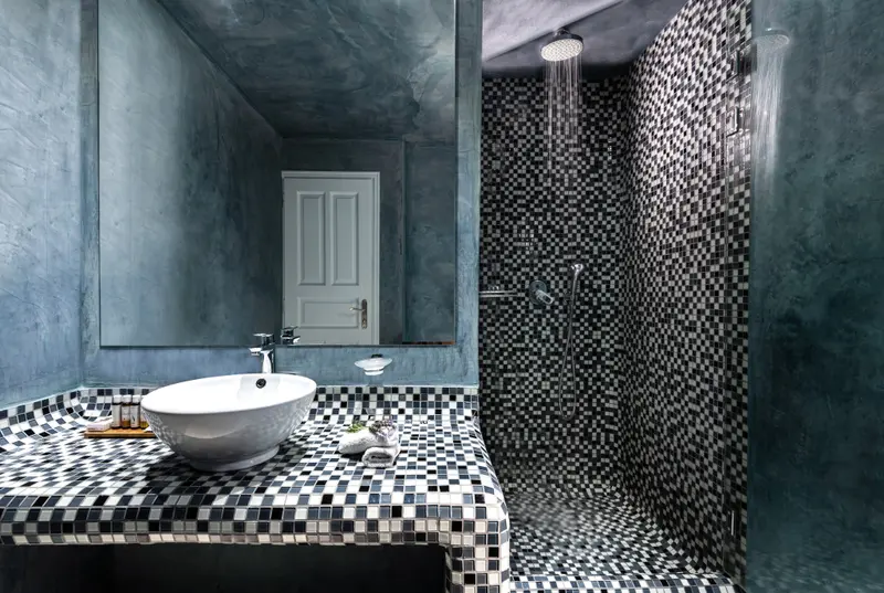 Une salle de bain moderne avec douche à l'italienne et vasque sur plan de travail carrelé.