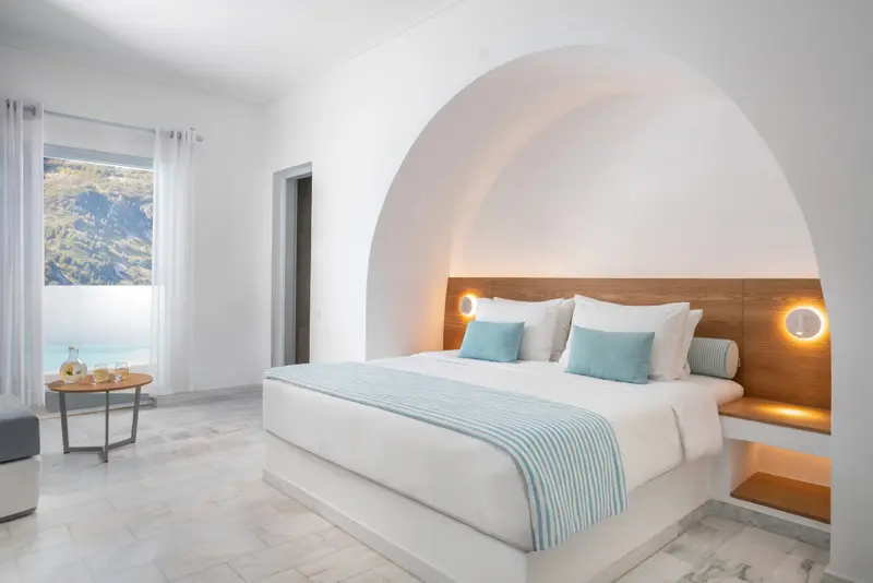 Une chambre lumineuse avec un grand lit et une vue sur la mer.