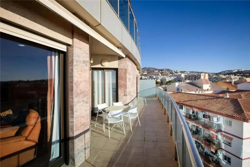 Une terrasse ensoleillée offre une vue sur la ville et les collines environnantes.