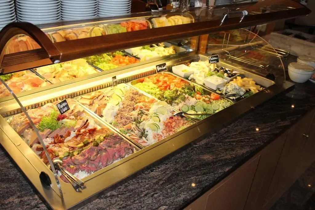 Un buffet propose une variété de plats froids et de salades colorées.