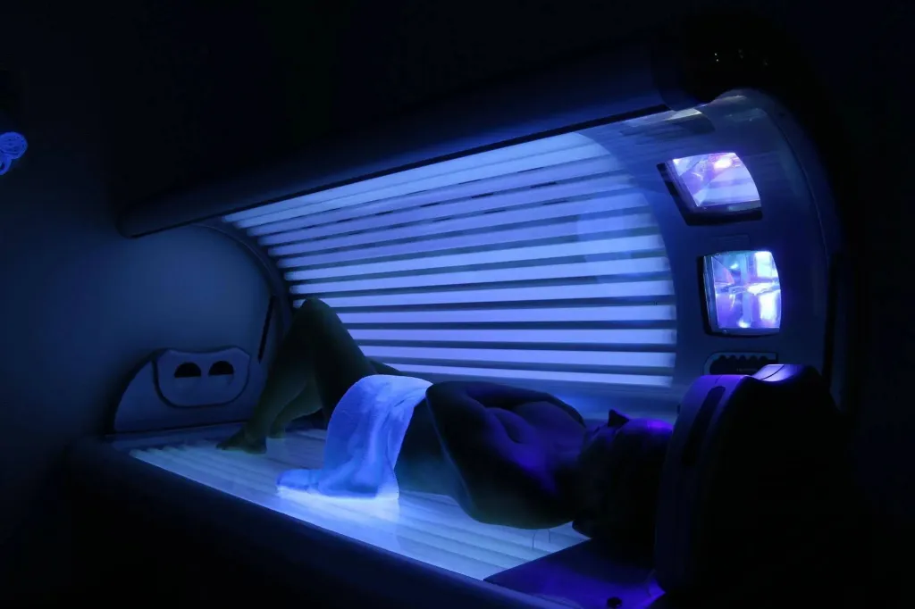 Une personne est allongée dans un appareil de bronzage.