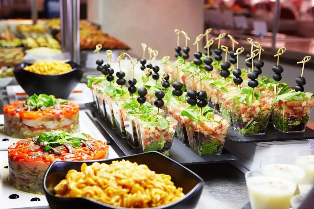 Présentation de divers plats froids et salades sur un buffet.