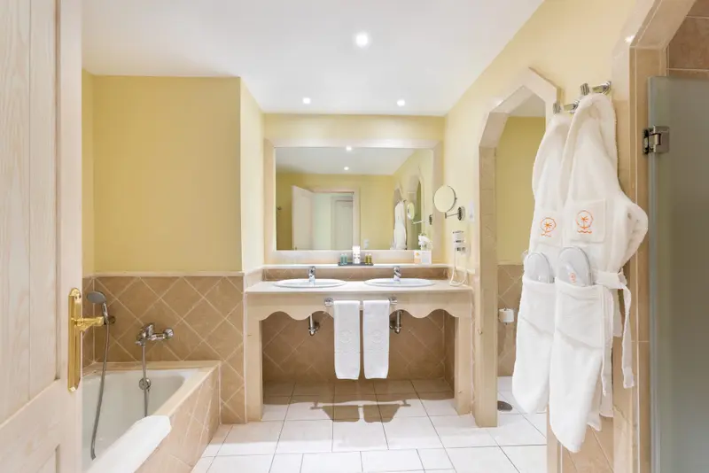 Une salle de bain lumineuse avec baignoire et double vasque.