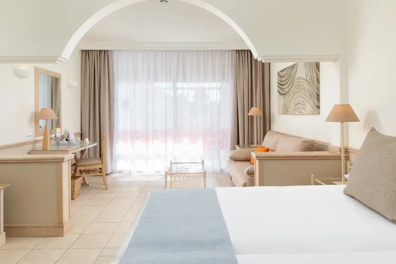 Une chambre lumineuse avec un lit et un espace salon.
