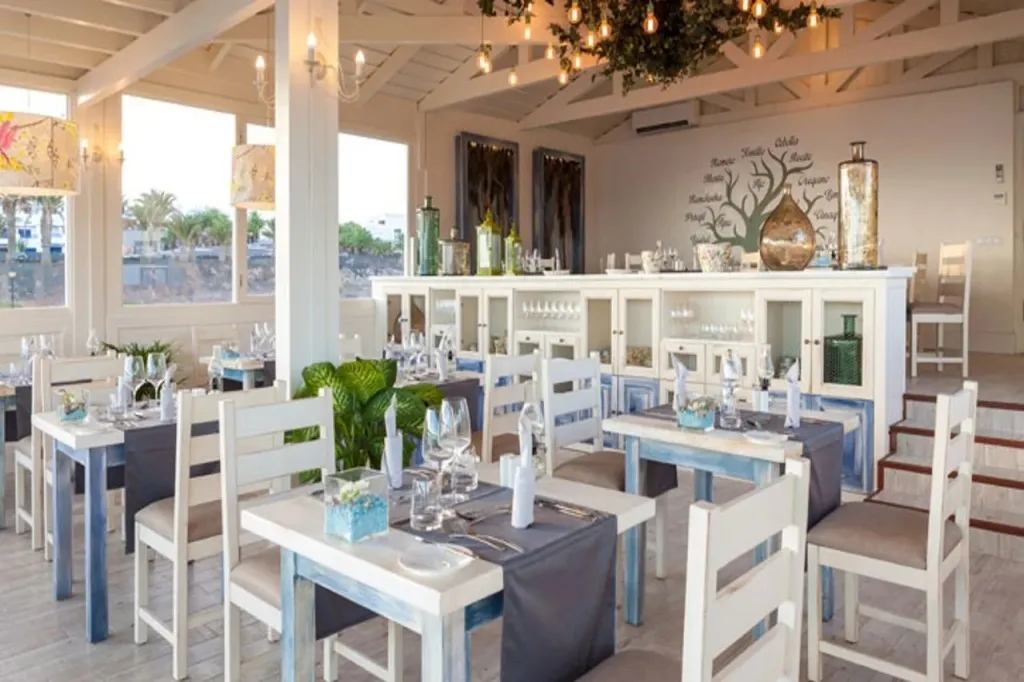 Une salle de restaurant lumineuse avec des tables dressées et une décoration florale.