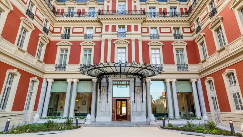 Façade d'un bâtiment à colonnes avec un auvent à l'entrée.