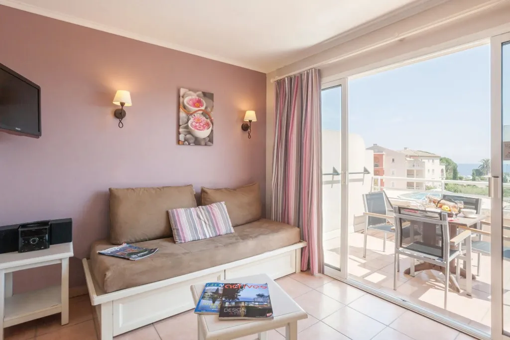 Un salon lumineux s'ouvre sur une terrasse avec vue sur la mer.