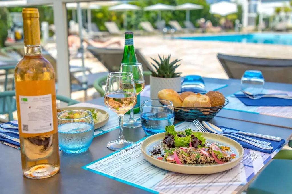 Une table est dressée avec des plats, des boissons et de la vaisselle.