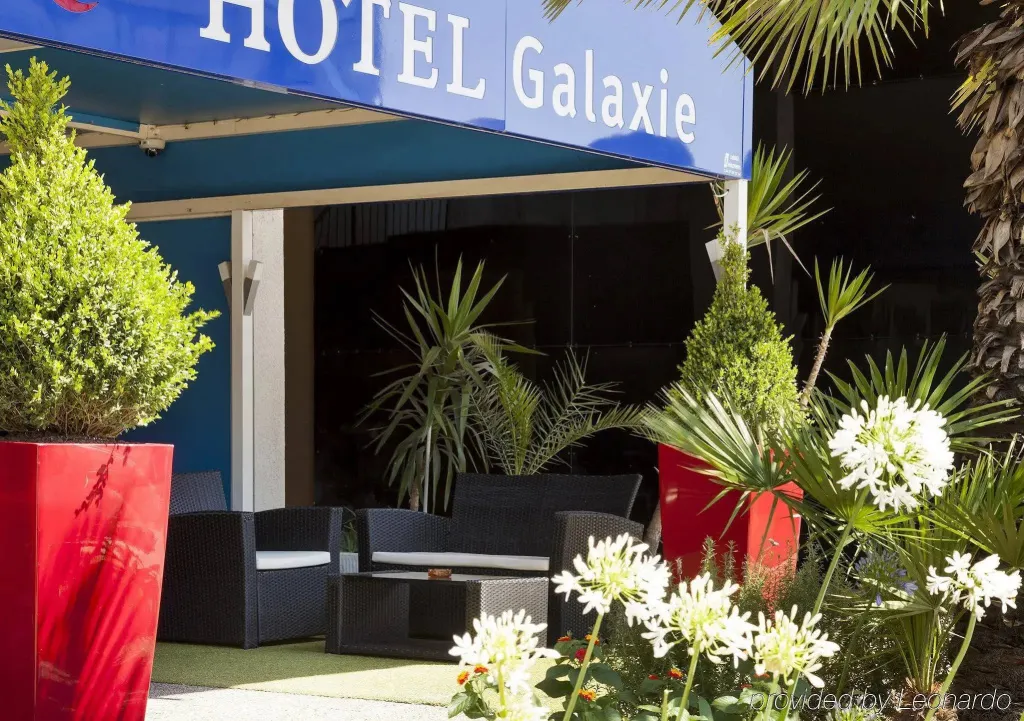 Terrasse ombragée avec mobilier d'extérieur et végétation luxuriante.
