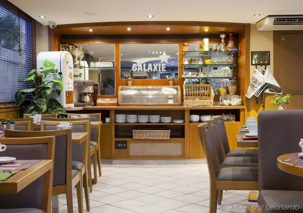 Une salle de restaurant lumineuse avec des tables et un comptoir de buffet.