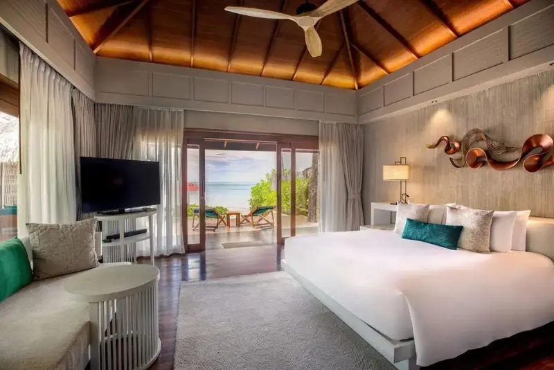 Une chambre lumineuse s'ouvre sur une terrasse avec vue sur la mer.