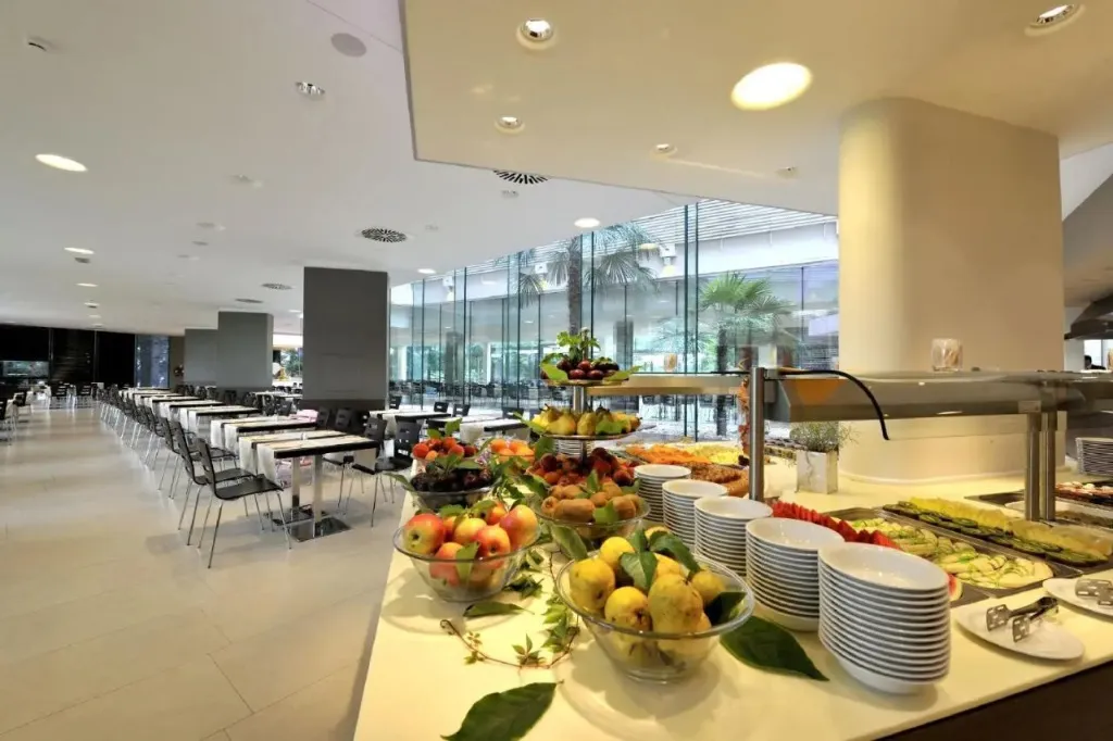 Un buffet de fruits frais est présenté dans une salle lumineuse avec de grandes fenêtres.
