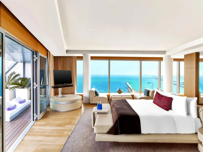 Une chambre lumineuse avec un grand lit et une vue sur la mer.