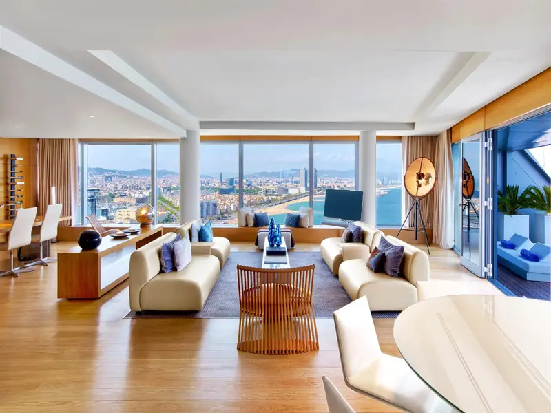 Vaste espace de séjour lumineux avec vue panoramique sur la ville et la mer.