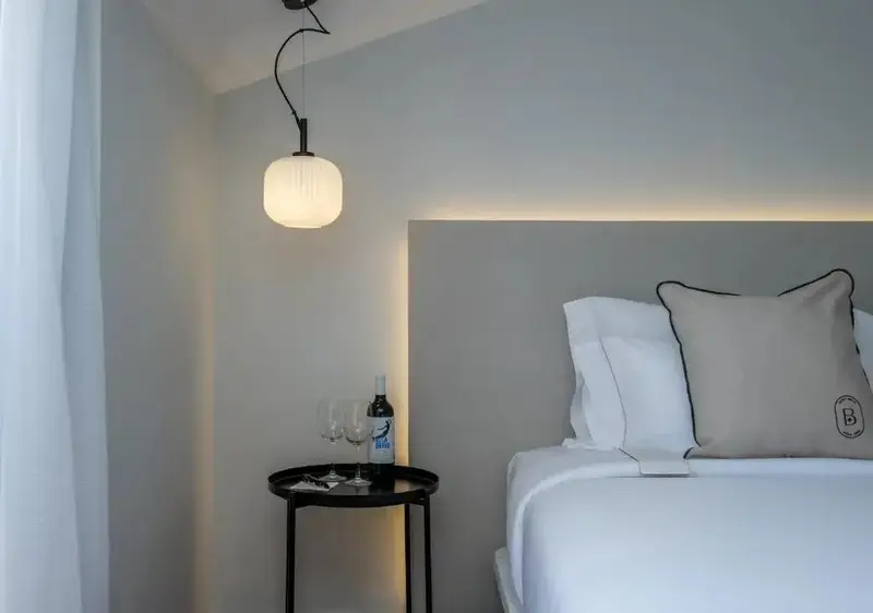Une chambre lumineuse avec un lit confortable et une table de chevet.