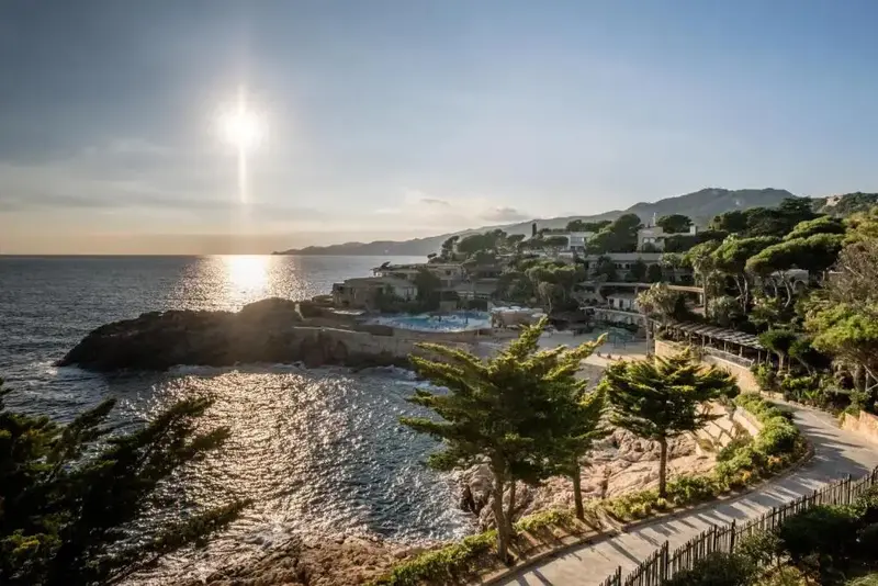 Vue d'un établissement sur le littoral rocheux, baigné par le soleil.