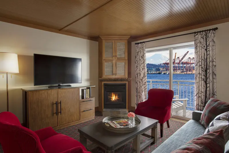 Un salon chaleureux avec une vue sur le port et les montagnes.