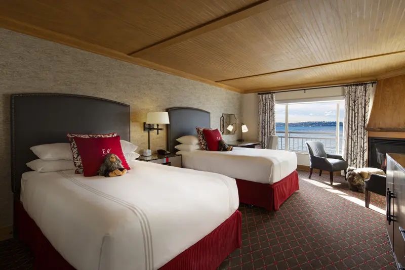 Une chambre lumineuse avec deux lits simples et une vue sur la mer.