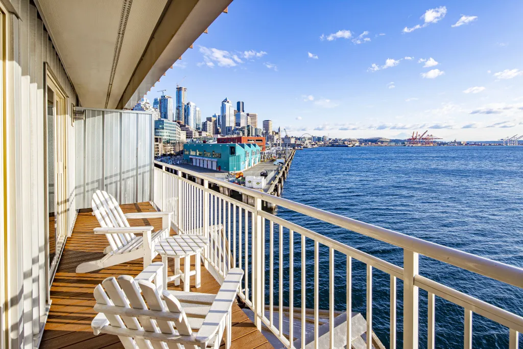 Vue sur la mer depuis une terrasse avec mobilier blanc.