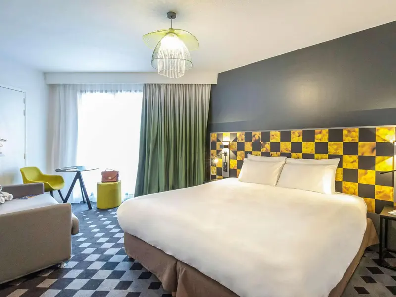 Une chambre lumineuse avec un grand lit et un décor moderne.