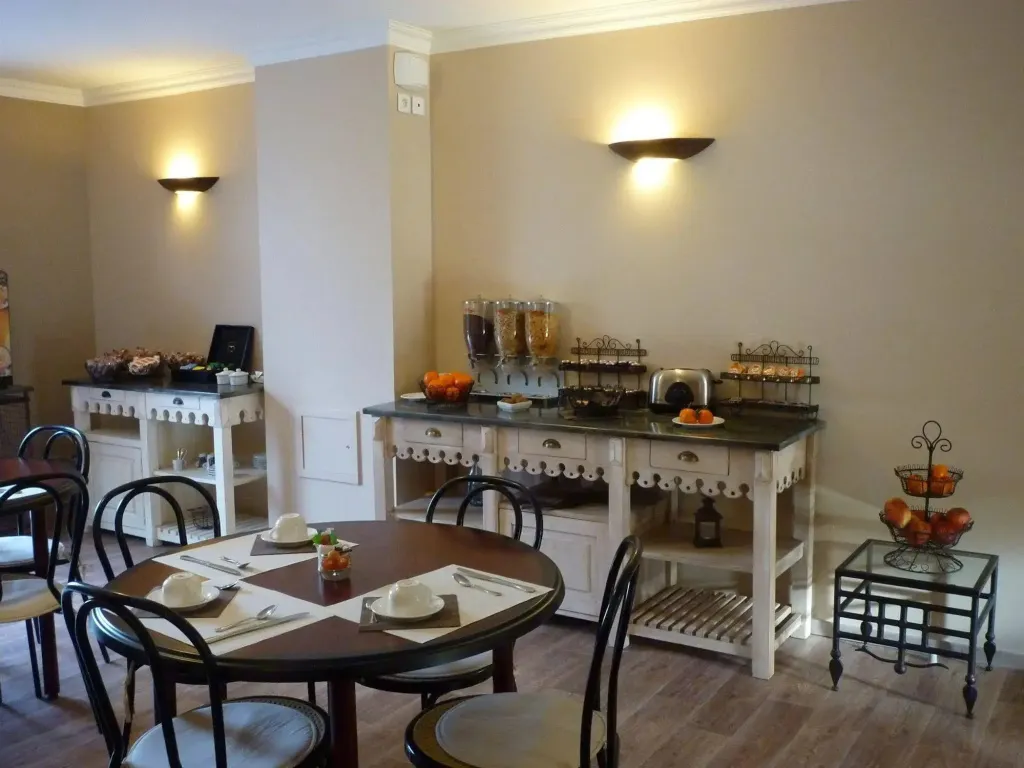 Une salle lumineuse avec des tables rondes et un buffet de petit-déjeuner.