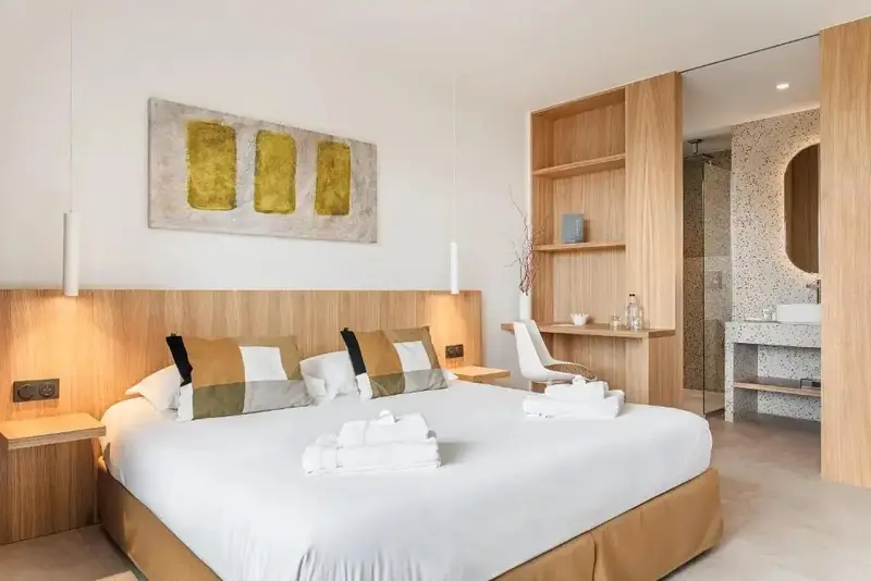Une chambre lumineuse avec un grand lit et une décoration moderne.
