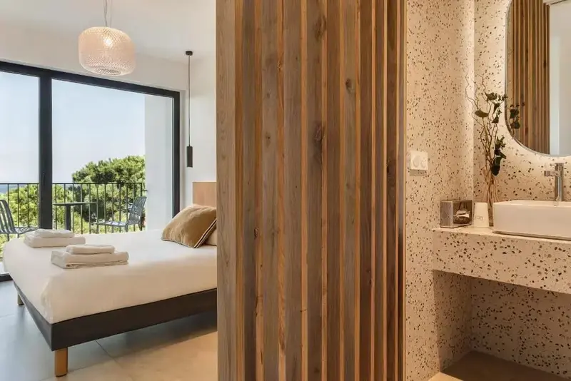 Une chambre lumineuse avec un grand lit et un coin lavabo moderne.