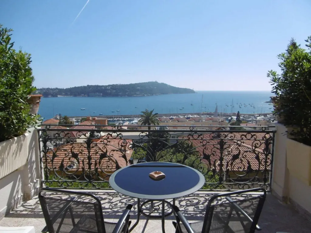 Vue dégagée sur la mer depuis une terrasse ensoleillée.