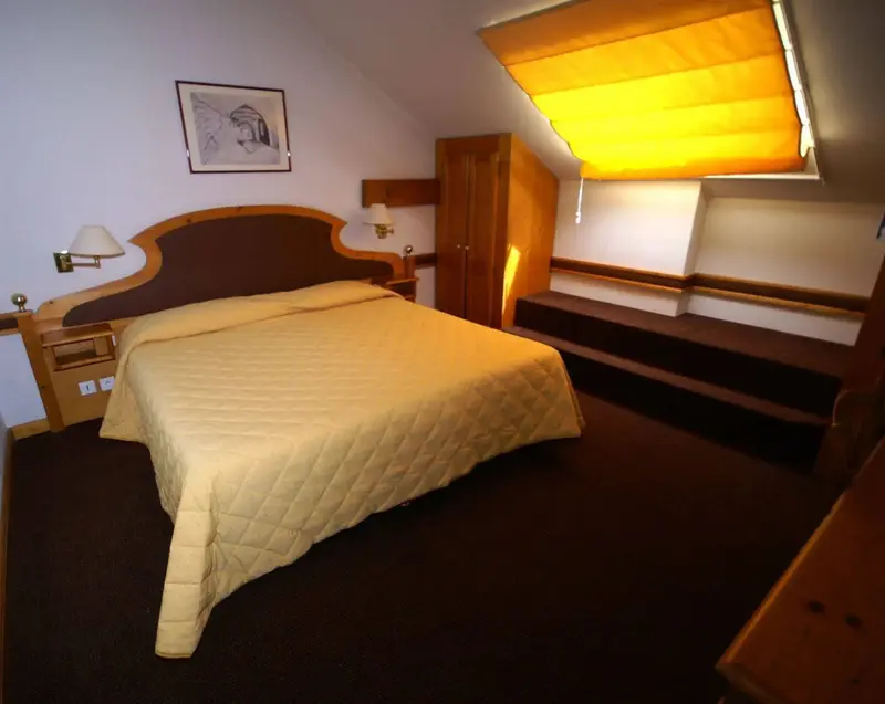 Une chambre à coucher lumineuse avec un lit recouvert d'une courtepointe jaune.