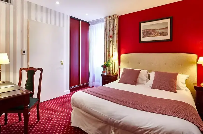 Une chambre d'hôtel lumineuse avec un lit double et un bureau.