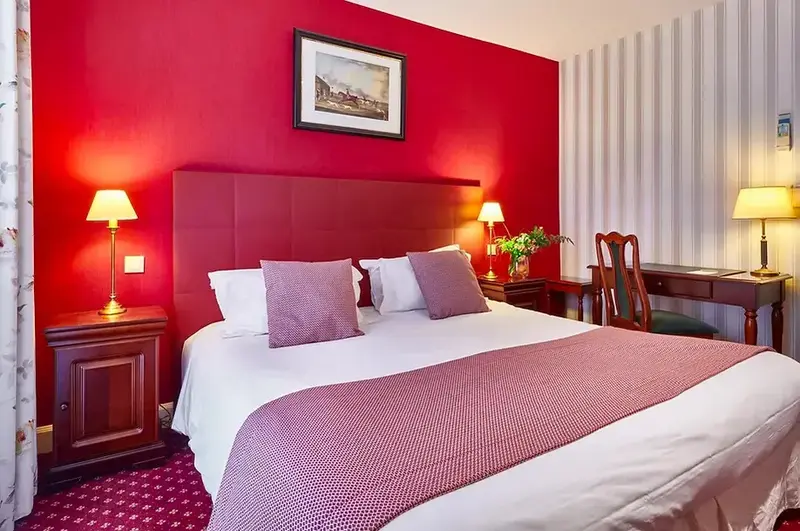 Une chambre à coucher avec un grand lit recouvert d'une courtepointe et de coussins.
