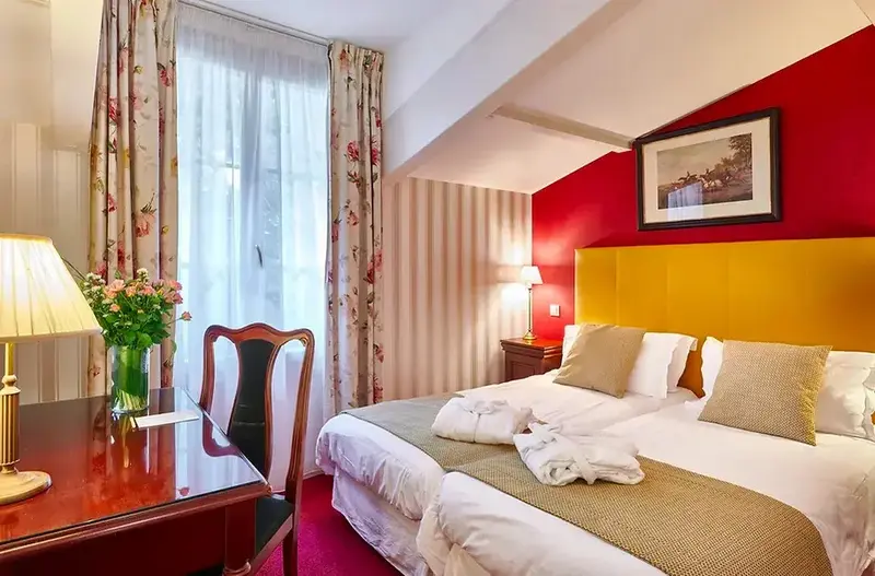 Une chambre lumineuse avec un bureau et un lit à deux personnes.
