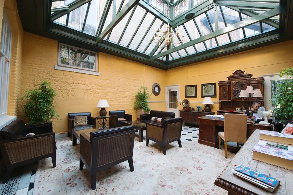 Espace de détente lumineux avec mobilier en bois et plantes.