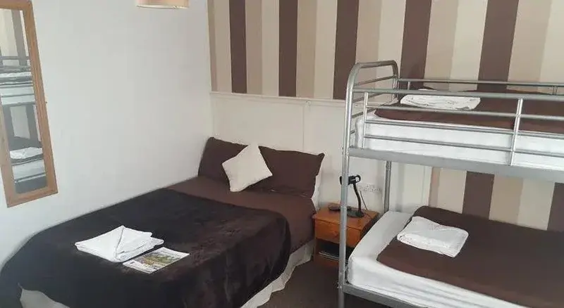 Une chambre avec un lit simple et un lit superposé.
