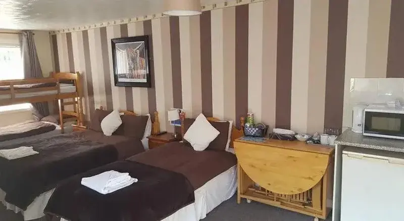 Une chambre avec lits simples et une kitchenette.