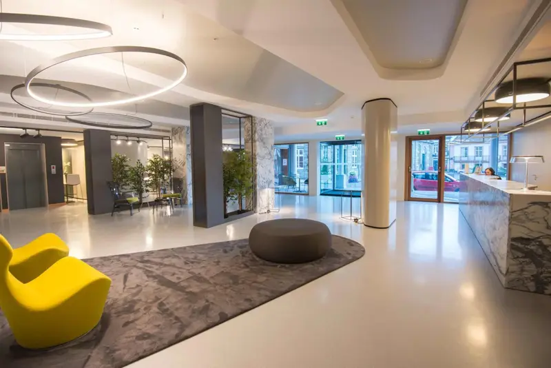 Un hall d'accueil moderne avec un comptoir de réception et des assises confortables.