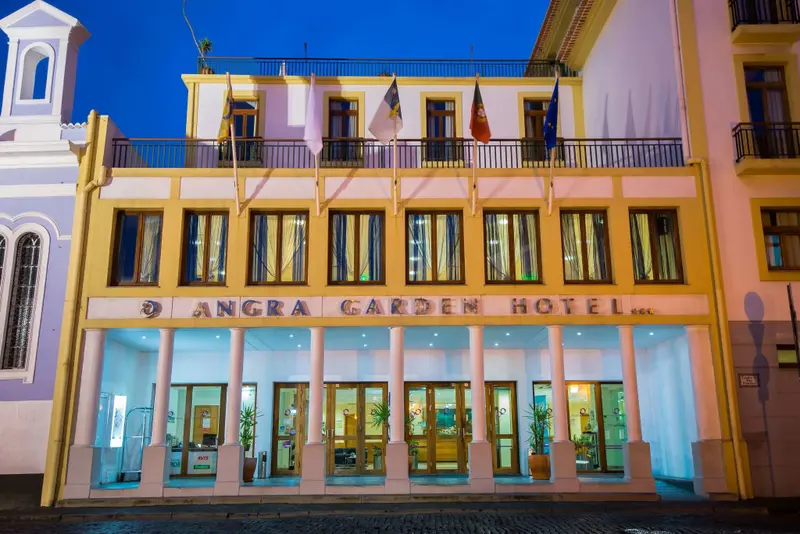 Façade d'un hôtel illuminé au crépuscule.