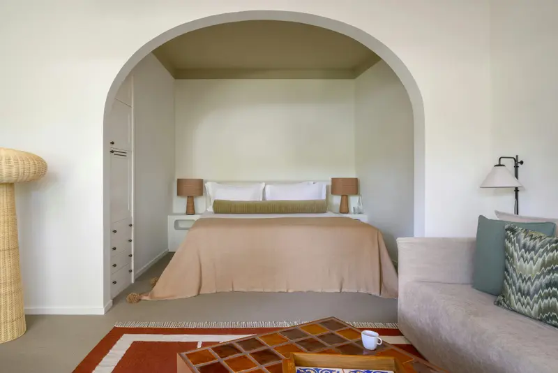 Une chambre à coucher lumineuse avec un lit fait et un espace détente.
