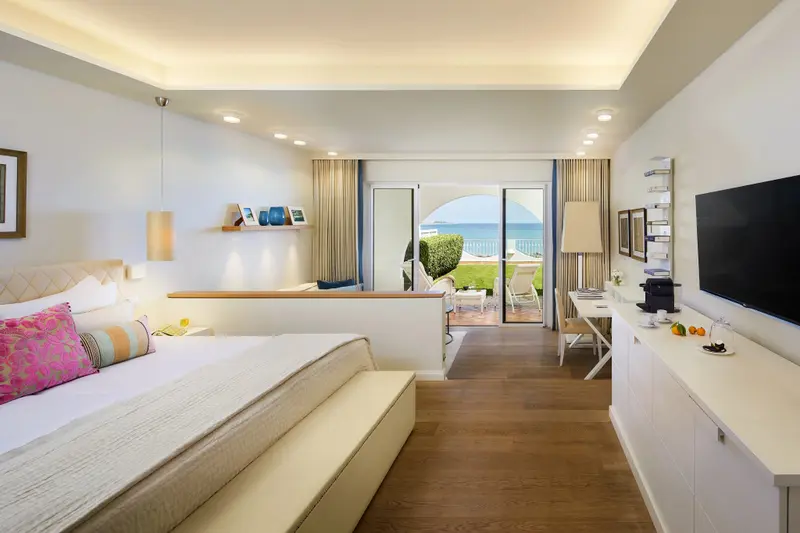 Une chambre lumineuse avec un grand lit et une vue sur la mer.