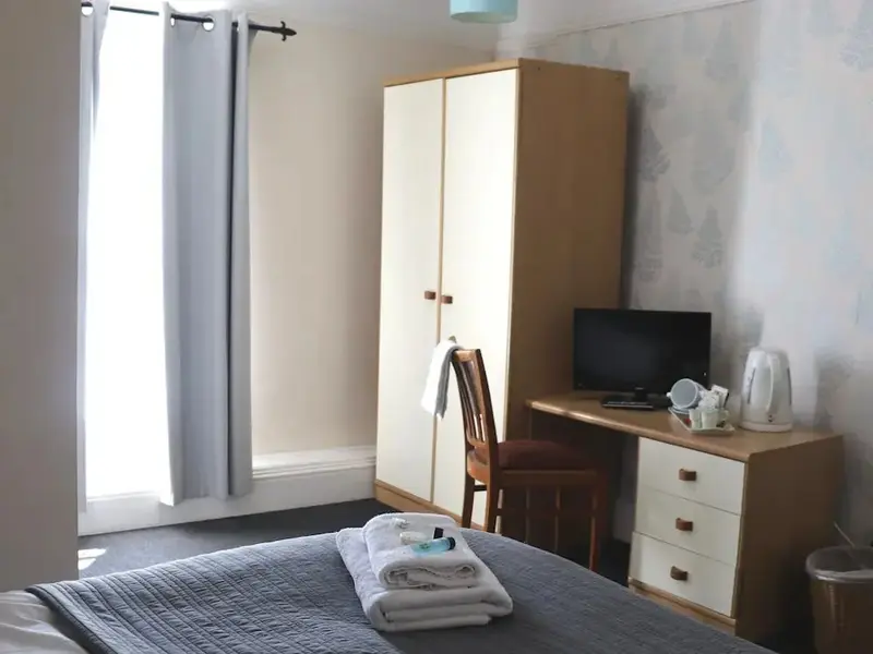 Une chambre avec un lit fait et un bureau.