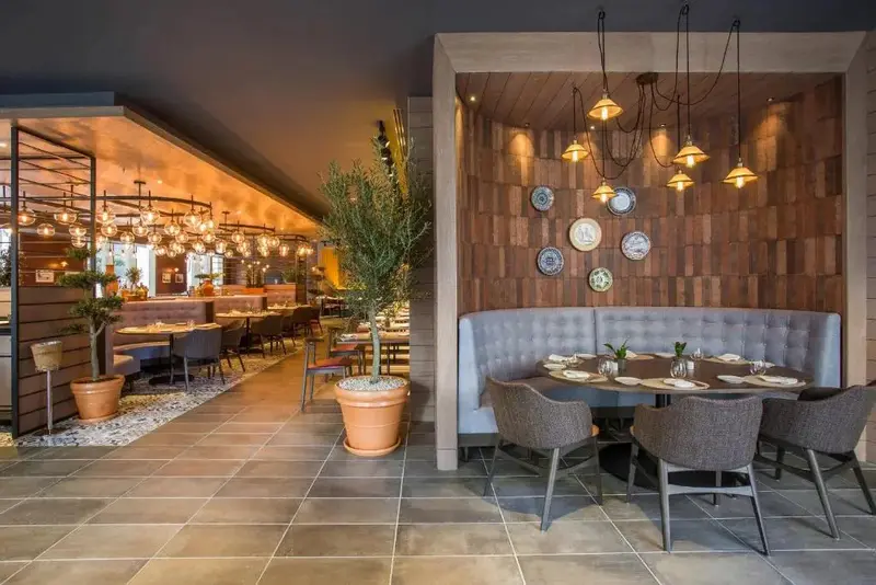 Une salle de restaurant lumineuse avec des tables et des banquettes.