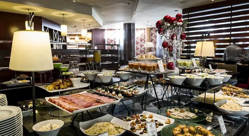 Un buffet généreux propose une variété de plats et de boissons dans une salle lumineuse.