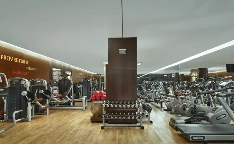 Une salle de sport lumineuse avec des équipements de musculation et cardiovasculaire.